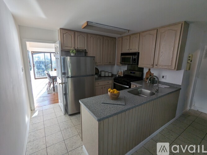 A kitchen with a refrigerator, sink, and microwave.
