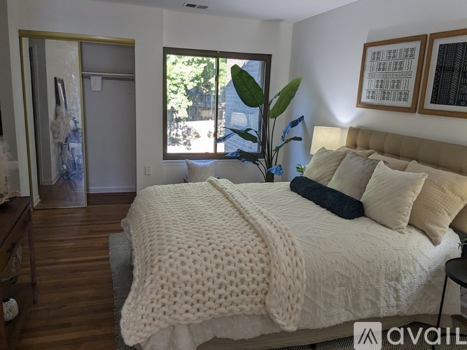 A bedroom with a large bed and a view of the outdoors through a sliding glass door.