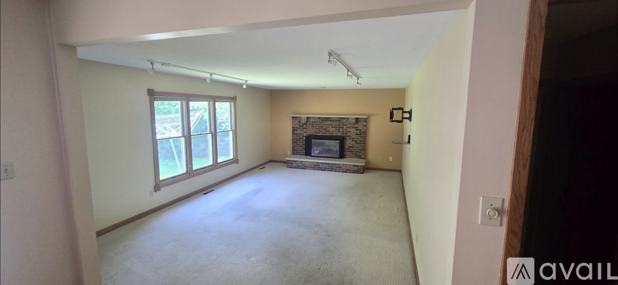 A living room with a fireplace and a large window.