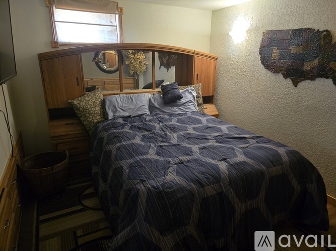 A bedroom with a bed covered in a blue and white patterned comforter.