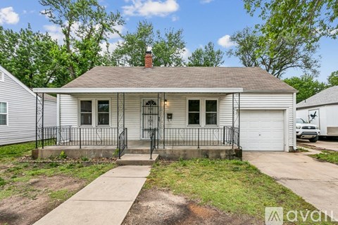 A small house with a front porch and a driveway.