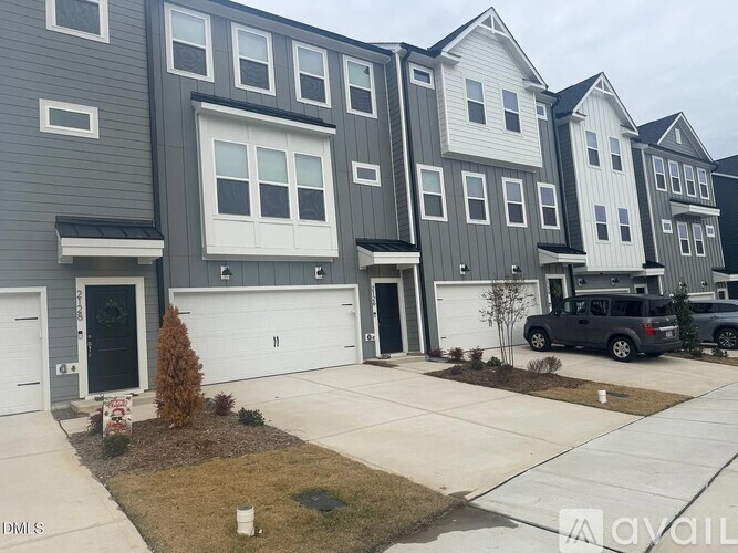 A row of houses with a car parked in front of the last one.