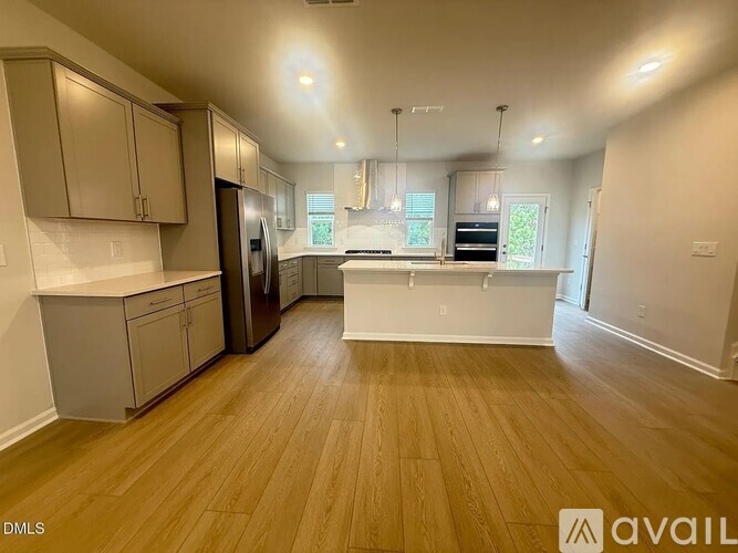 A kitchen with wooden floors and white walls.