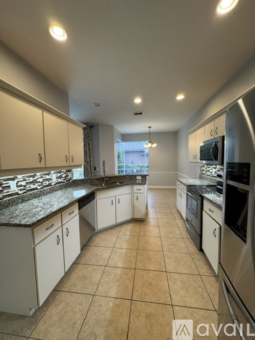 A kitchen with white cabinets and appliances.