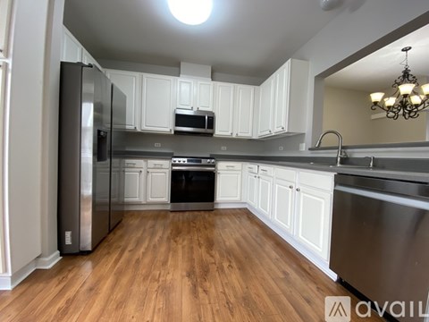 A kitchen with white cabinets and stainless steel appliances.