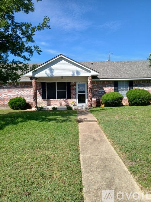A house with a brick facade and a grey roof is shown.
