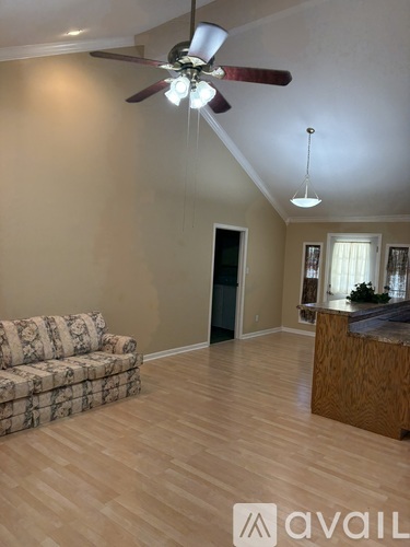 A living room with a couch and a ceiling fan.