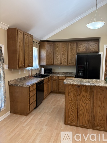 A kitchen with wooden cabinets and a granite countertop.