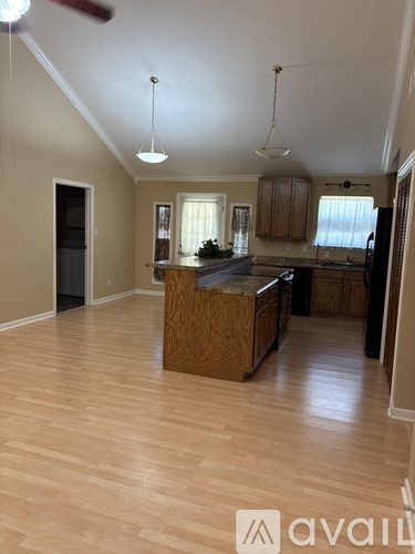 A kitchen with wooden cabinets and a black refrigerator.