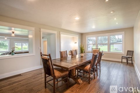 A dining room with a wooden table and chairs.