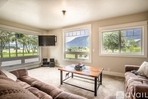A living room with a brown couch and a flat screen TV.