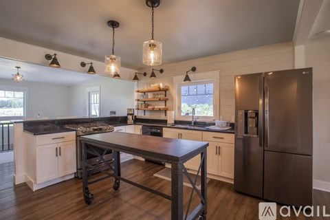 A kitchen with a table and a refrigerator.