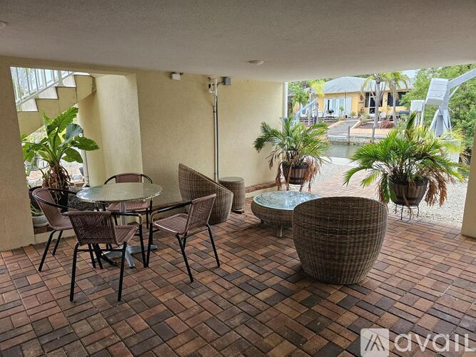 A patio with a table and chairs and a potted plant.