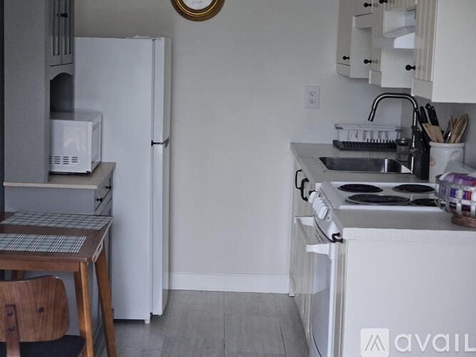 A kitchen with a white fridge, stove, and sink.