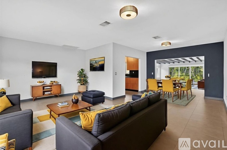A living room with a grey couch and a yellow pillow.