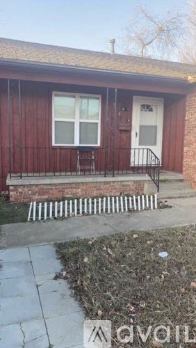A red house with a white door and a small porch.