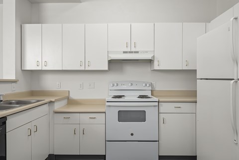A white kitchen with a stove and cabinets.