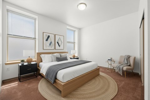 A bedroom with a large bed and a chair.