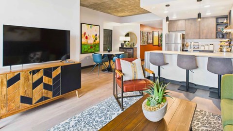 A living room with a television, a bar, and a potted plant.