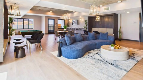 A modern living room with a pool table and a large sectional sofa.