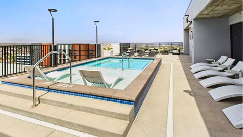 A pool with a metal railing and a black gate.