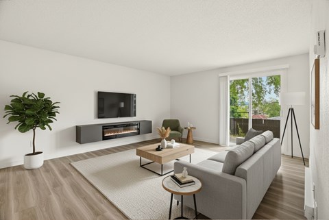 A living room with a grey couch, a wooden coffee table, a television, and a plant.