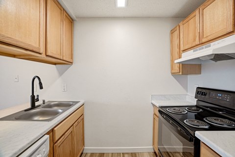 A kitchen with wooden cabinets and a black stove top oven.