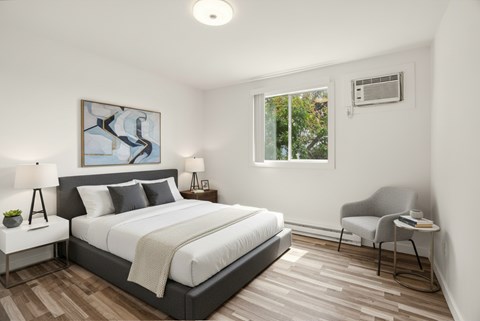 A bedroom with a large bed and a chair.