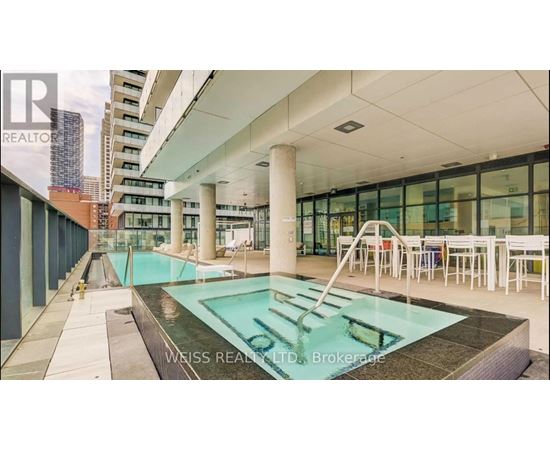 A pool in a building with a glass wall.