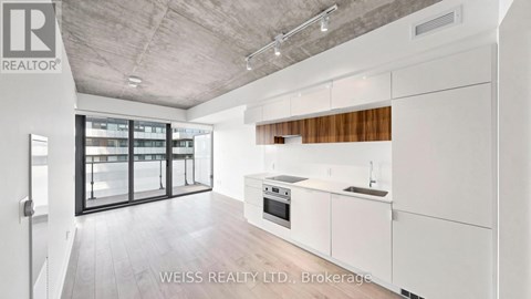 A modern kitchen with white cabinets and a wooden backsplash.