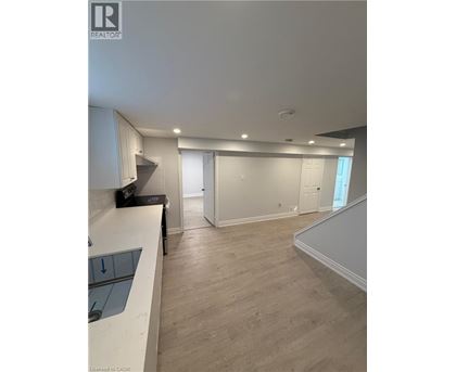 A spacious room with a staircase and a counter.