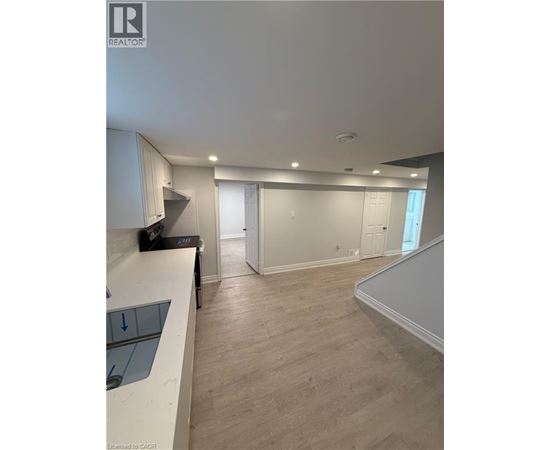 A spacious room with a staircase and a counter.
