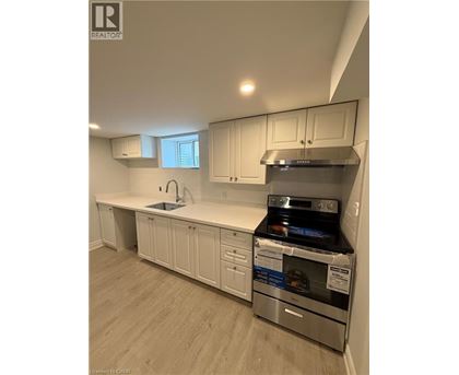 A kitchen with white cabinets and a stainless steel oven.