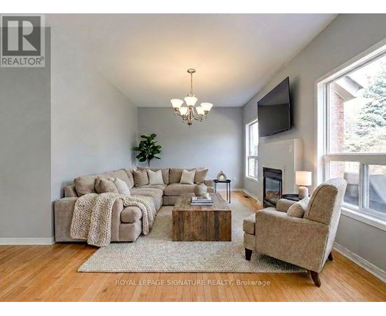 A living room with a large couch, a coffee table, and a television.