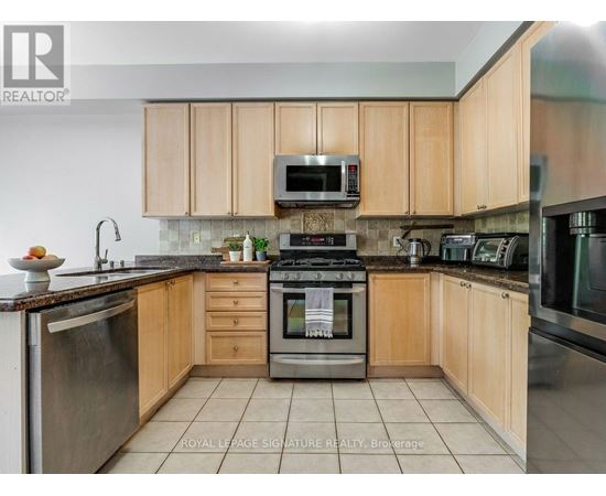 A kitchen with wooden cabinets and stainless steel appliances.