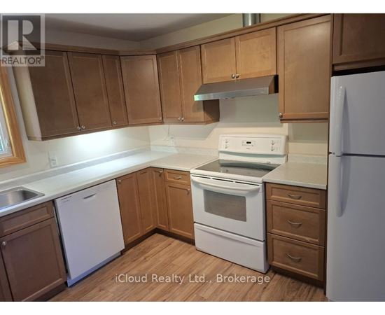 A kitchen with wooden cabinets and white appliances.