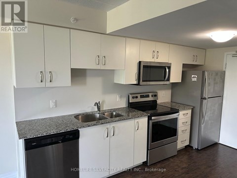 A kitchen with white cabinets and a granite countertop.