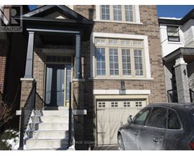 A grey car is parked in front of a house with a Royal LePage sign.