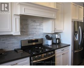 A kitchen with a black countertop and a stove with four burners.