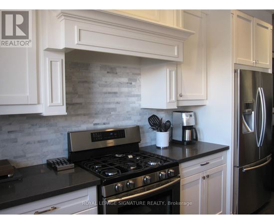 A kitchen with a black countertop and a stove with four burners.