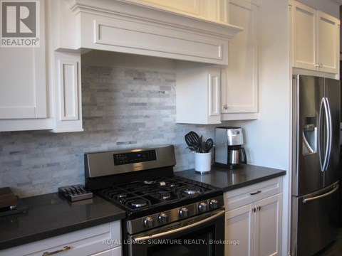 A kitchen with a black countertop and a stove with four burners.