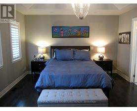 A bedroom with a large bed and a chandelier.
