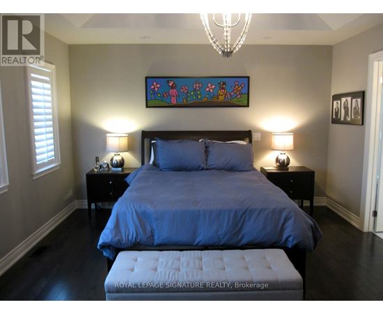A bedroom with a large bed and a chandelier.