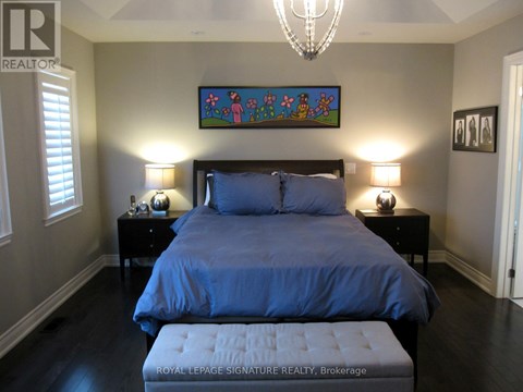 A bedroom with a large bed and a chandelier.