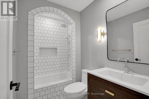 A bathroom with a white tiled shower and a white toilet.