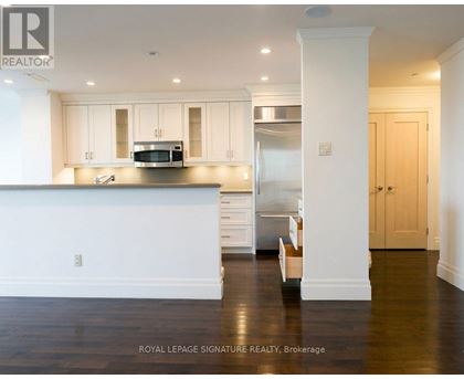 A kitchen with white cabinets and a stainless steel refrigerator.