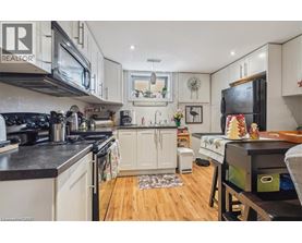 A kitchen with white cabinets and black countertops.