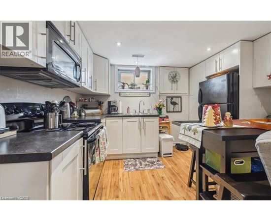 A kitchen with white cabinets and black countertops.