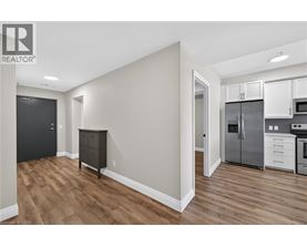 A kitchen with white cabinets and a wooden floor.