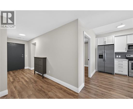 A kitchen with white cabinets and a wooden floor.